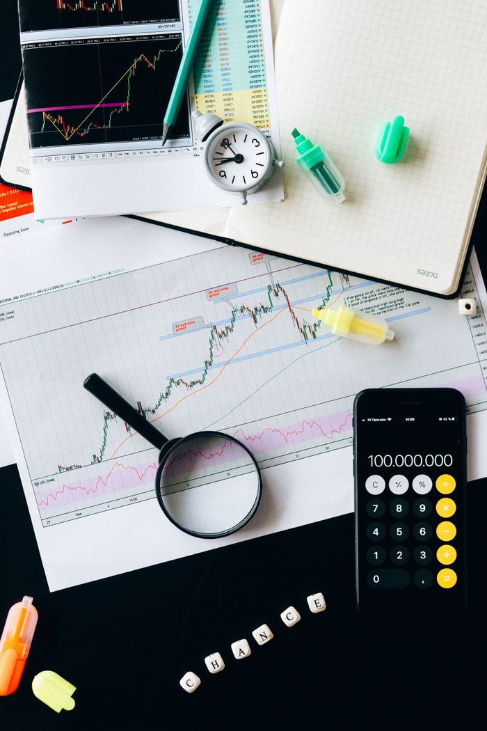 About Stock market analysis setup with graphs, calculator, and magnifying glass.