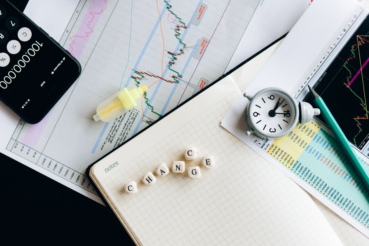 Top view of financial documents with charts, calculator, clock, and the word Change in focus.
